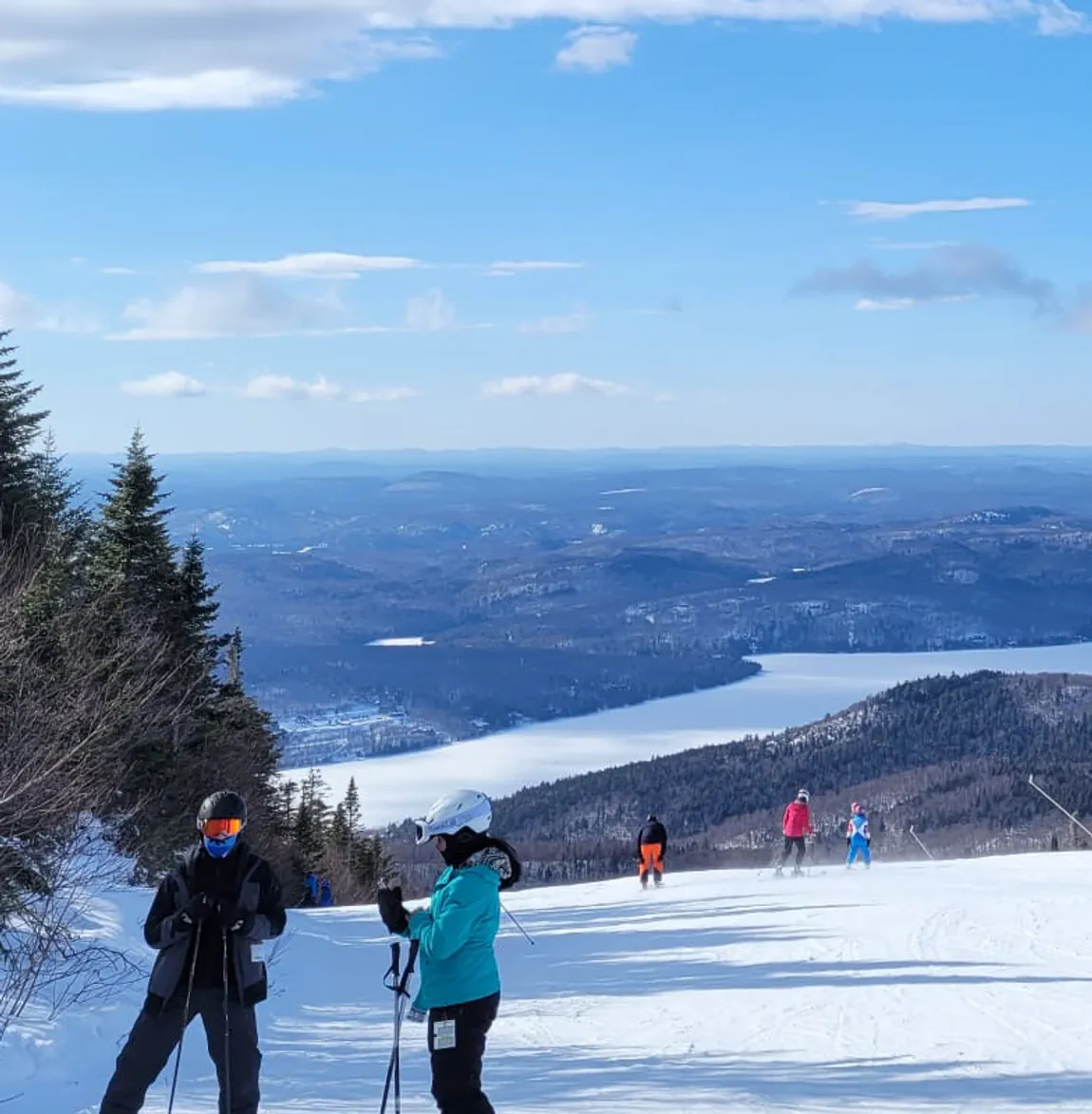 A cropped frame of a winter mountain range with Lukas in foreground in ski gear.