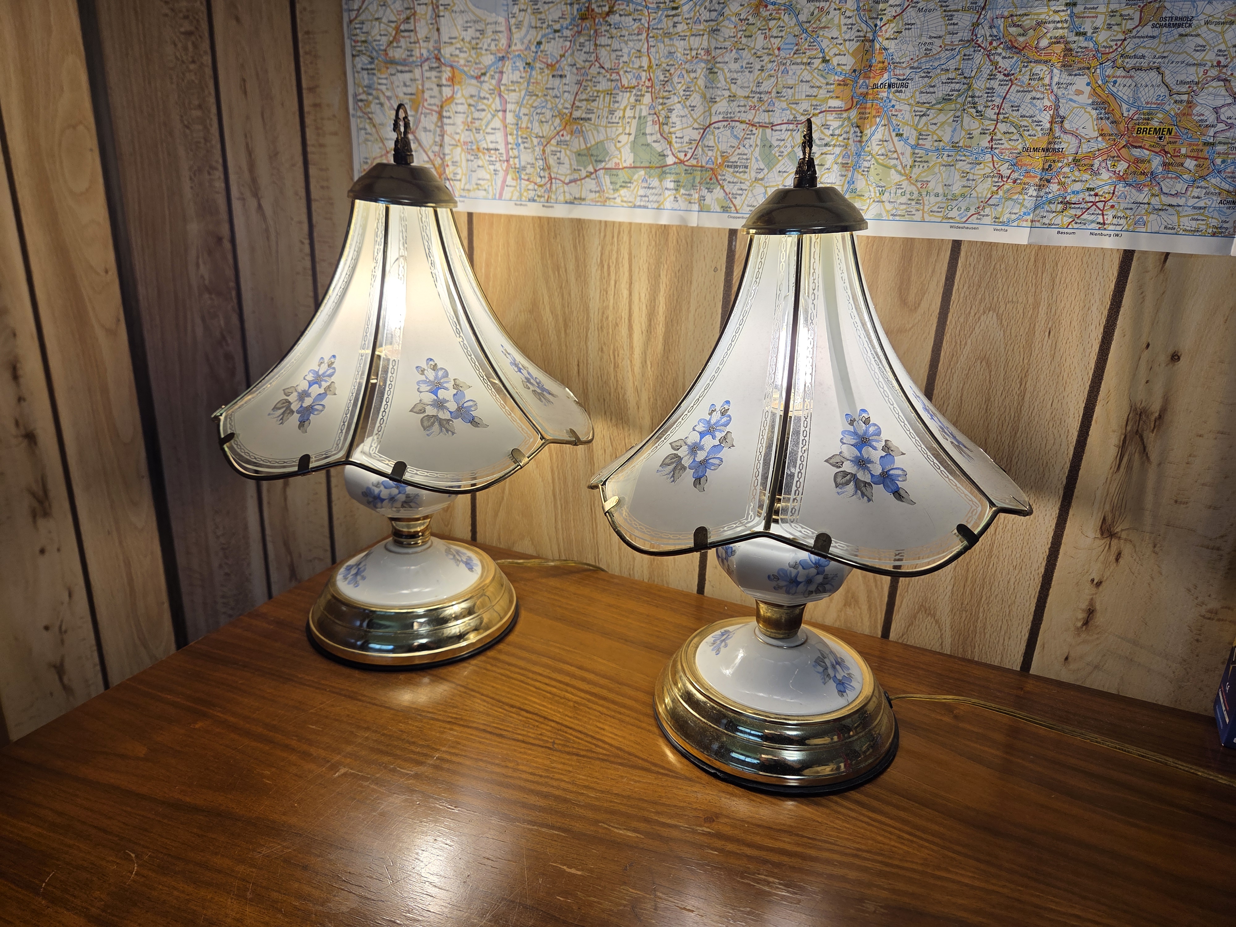 The two touch lamps at full brightness next to each other on a wooden dresser.